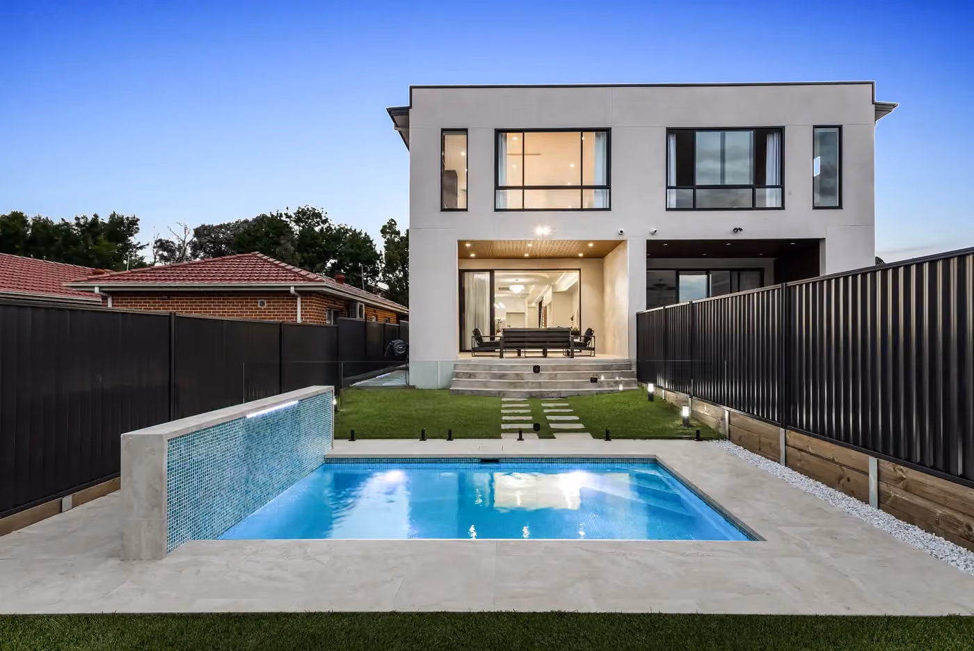 Pool and rear of the house at dusk, straight on